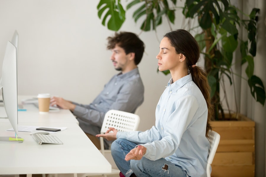 Woman meditating at work | DNAfit Blog