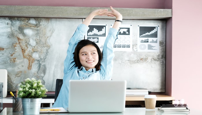 Woman stretching at her desk | DNAfit Blog
