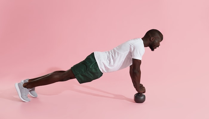 Man doing core exercise with dumbell | DNAfit Blog